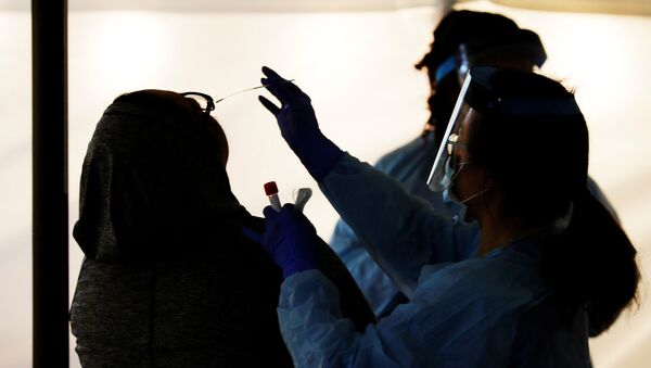 Medical personnel swab an employee’s nose at a drive-through testing site for coronavirus for employees at UW Medical Center Northwest in Seattle, Washington - Sputnik Азербайджан