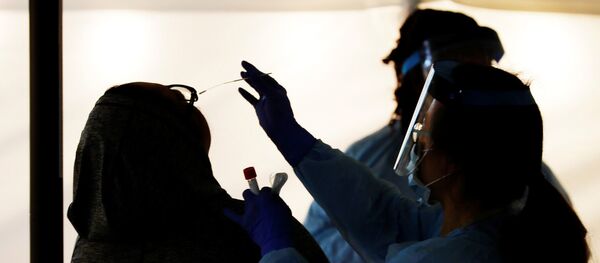 Medical personnel swab an employee’s nose at a drive-through testing site for coronavirus for employees at UW Medical Center Northwest in Seattle, Washington - Sputnik Азербайджан