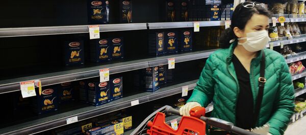 A woman wearing a protective face mask passes by a partly empty self of pasta as she shops in a super market in Athens, Greece A woman wearing a protective face mask passes by a partly empty self of pasta as she shops in a super market in Athens, Greece - Sputnik Азербайджан