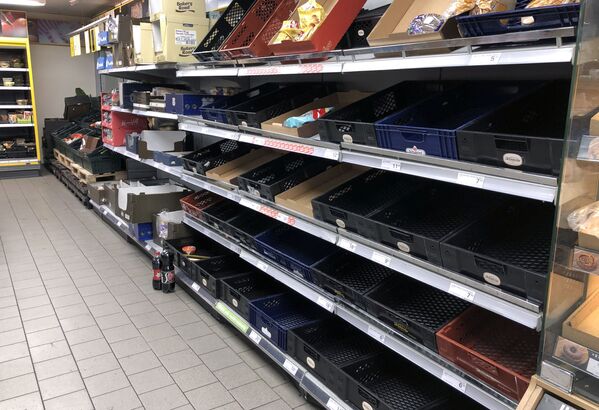 A view of empty shelves at a supermarket as people began stockpiling food just hours after the Danish government introduced measures to contain the spread of the coronavirus in Copenhagen - Sputnik Азербайджан