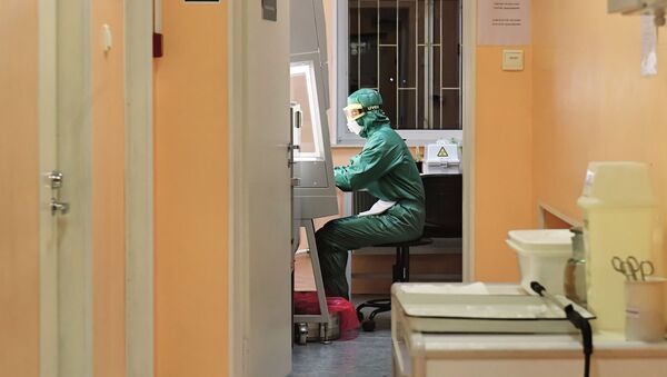 Сотрудник лаборатории во время тестирования проб на коронавирус, фото из архива - Sputnik Азербайджан