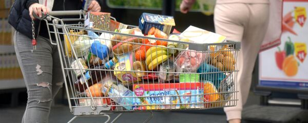 Покупатель с тележкой, наполненной продуктами в супермаркете - Sputnik Азербайджан