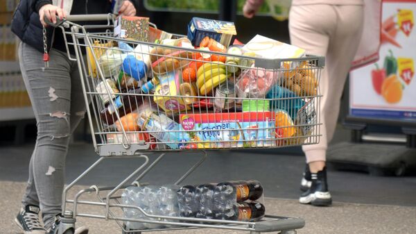 Покупатель с тележкой, наполненной продуктами в супермаркете - Sputnik Азербайджан