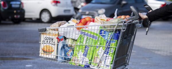 Покупатель с тележкой, наполненной продуктами в супермаркете - Sputnik Азербайджан