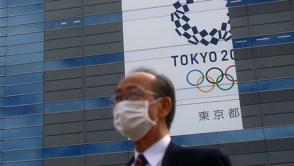 Человек на фоне олимпийской символики в Токио, фото из архива  - Sputnik Azərbaycan