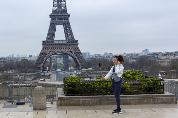 Туристка фотографируется на безлюдной площади Трокадеро у Эйфелевой башни в Париже - Sputnik Азербайджан