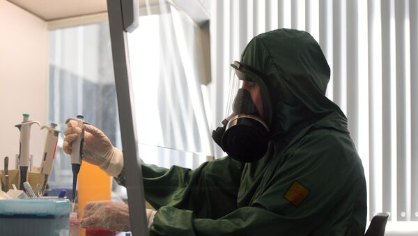 Сотрудник в костюме биозащиты за работой в вирусологической лаборатории - Sputnik Азербайджан