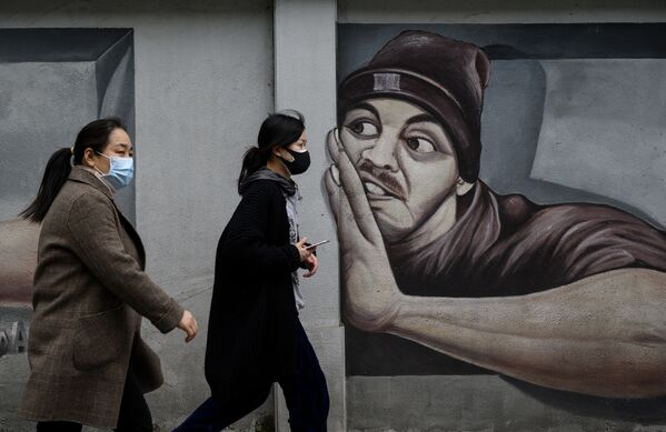Девушки в масках напротив граффити в Ухане  - Sputnik Azərbaycan