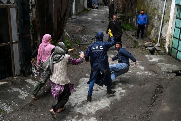 ocal residents start a fight with a municipal worker (C) as they allegedly accuse him not to have sanitised properly their house at a residential area declared Red Zone for coronavirus by authorities during a government-imposed nationwide lockdown as a preventive measure against the COVID-19 coronavirus, in Srinagar - Sputnik Azərbaycan