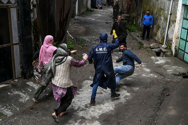 ocal residents start a fight with a municipal worker (C) as they allegedly accuse him not to have sanitised properly their house at a residential area declared Red Zone for coronavirus by authorities during a government-imposed nationwide lockdown as a preventive measure against the COVID-19 coronavirus, in Srinagar ocal residents start a fight with a municipal worker (C) as they allegedly accuse him not to have sanitised properly their house at a residential area declared Red Zone for coronavirus by authorities during a government-imposed nationwide lockdown as a preventive measure against the COVID-19 coronavirus, in Srinagar - Sputnik Азербайджан