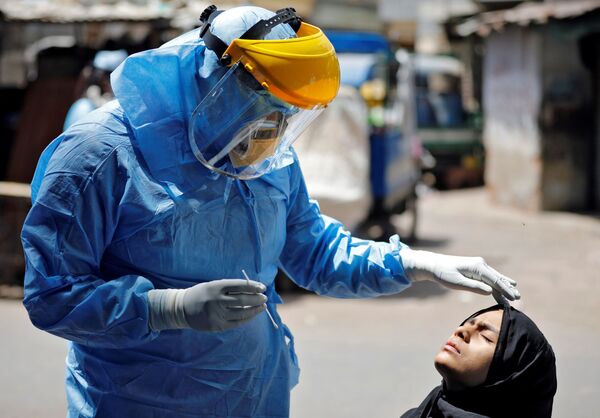 Доктор в защитном костюме тестирует девушку на коронавирус в Ахмедабаде, Индия - Sputnik Azərbaycan
