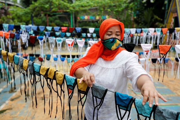 A woman puts cloth face masks on a string to dry before distributing it for free around the neighbourhood, amid the spread of coronavirus disease (COVID-19) outbreak, in Tangerang, on the outskirts of Jakarta, Indonesia - Sputnik Azərbaycan