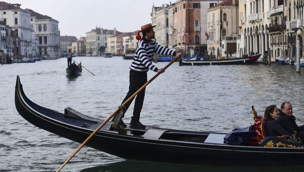 Гондольер переправляет туристов вдоль Большого канала в Венеции - Sputnik Azərbaycan