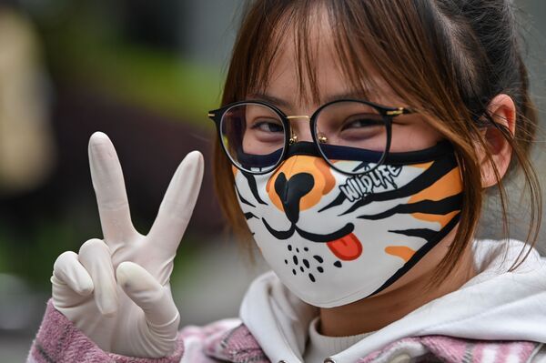A woman wearing a face mask gestures on a street in Wuhan, China's central Hubei province - Sputnik Азербайджан