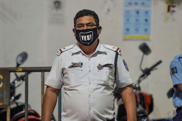 A police personnel wears a facemask as he stands on a street during a government-imposed nationwide lockdown as a preventive measure against the COVID-19 coronavirus, in Siliguri  - Sputnik Азербайджан