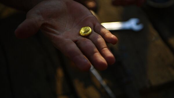 Золотодобытчик показывает кусочек золота, фото из архива - Sputnik Azərbaycan