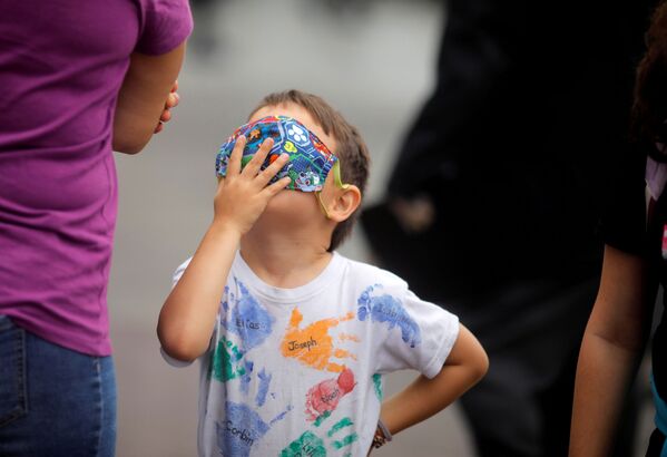 A Canadian child plays with a mask as Canadian citizens and residents stranded in Peru prepare to catch a flight bound to Canada organized by their embassy as the spreading of the coronavirus disease (COVID-19) continues, outside the Canada embassy in Lima, Peru  - Sputnik Азербайджан