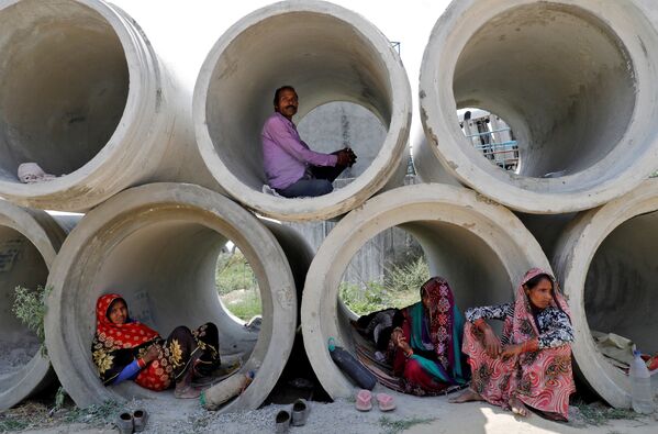 Migrant labourers rest in cement pipes during an extended nationwide lockdown to slow the spreading of coronavirus disease (COVID-19) in Lucknow, India - Sputnik Azərbaycan