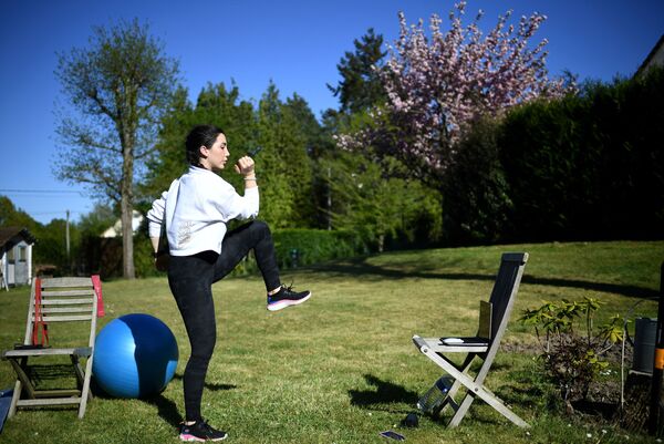 Fitness coach Gabrielle Friscira gives a lesson by videoconference in Saint-Remy-l’Honore, west of Paris - Sputnik Azərbaycan