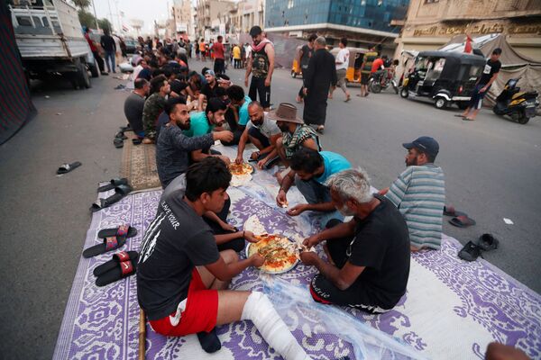 Во время приема пищи на площади Тахрир в Багдаде - Sputnik Azərbaycan