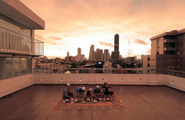 A family break their fast at the end of the first day of the holy month of Ramadan on a rooftop of their home during the curfew amid concerns about the spread of the coronavirus disease (COVID-19), in Colombo, Sri Lanka April 25, 2020 - Sputnik Azərbaycan