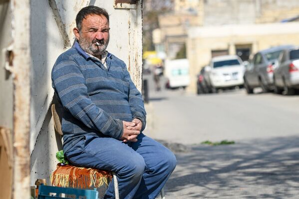 Мужчина сидящий на стуле на одной из улиц  в Баку - Sputnik Азербайджан