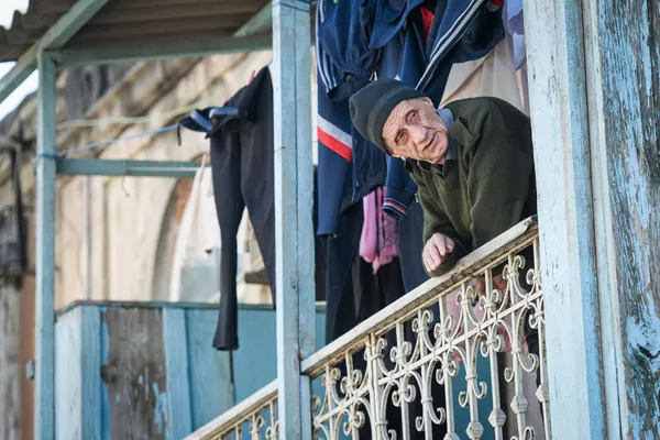 Пожилой мужчина на одной балконов  в Баку