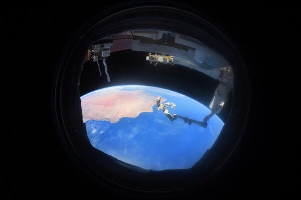 Снимок Земли через иллюминатор, сделанный на МКС космонавтом Антоном Шкаплеровым - Sputnik Azərbaycan