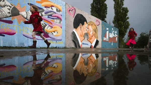 Граффити  президента США Трампа (справа) и президента Китая Си Цзиньпина, целующихся в масках на стене общественного парка Мауэрпарк в Берлине, Германия, фото из архива - Sputnik Azərbaycan