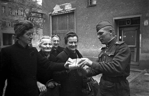 Советский солдат раздает хлеб женщинам Берлина, 7 мая 1945 года - Sputnik Азербайджан