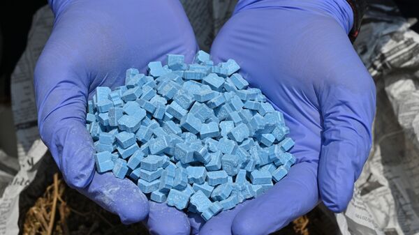 Полицейский демонстрирует синтетический наркотик метилендиоксиметамфетамин (MDMA), фото из архива - Sputnik Azərbaycan