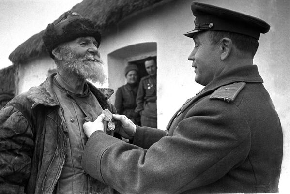 Командир дивизиона награждает колхозника Помкина за подвиг. 3-ий Украинский фронт. 1945 год - Sputnik Азербайджан