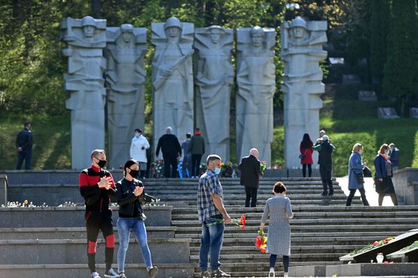 В Литве, несмотря на карантин, жители столицы отправились к мемориалам павших советских воинов, чтобы возложить цветы в честь их подвига  - Sputnik Azərbaycan