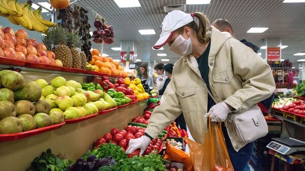 Женщина в защитной маске покупает овощи  - Sputnik Azərbaycan