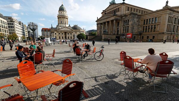 Люди наслаждаются погодой в кафе на площади Жандарменмаркт в Берлине, соблюдая принцип социальной дистанции - Sputnik Azərbaycan