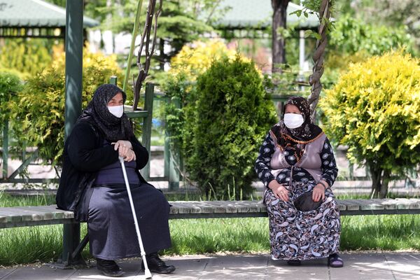 Пожилые женщины в медицинских масках на скамейке в одном из парков Анкары, Турция - Sputnik Azərbaycan