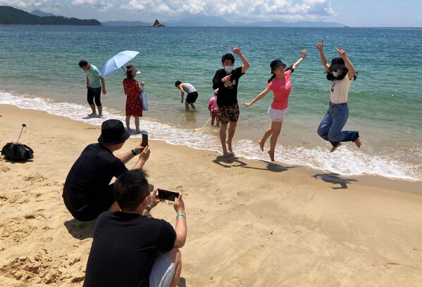 Люди в масках на пляже во время фотогарфирования в Китае  - Sputnik Азербайджан