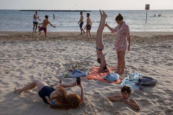 Люди во время отдыха на пляже в Тель-Авиве  - Sputnik Азербайджан