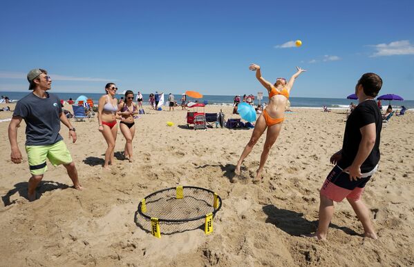 Молодые люди развлекаются на пляже в Оушен-Сити, штат Мэриленд, США - Sputnik Азербайджан