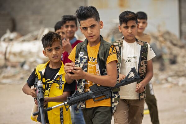 Дети с игрушечным оружием в руках в иракском городе Басра, Ирак - Sputnik Азербайджан