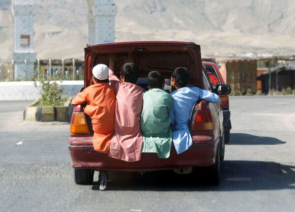 Афганские дети едут в багажнике автомобиля в провинции Лагман, Афганистан - Sputnik Azərbaycan