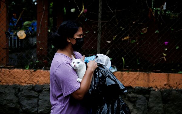 Женщина в защитной маске и с котом во время наводнения, вызванного тропическим штормом Аманда в Илопанго, Сальвадор - Sputnik Азербайджан