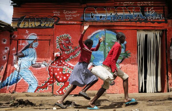 Бегущие дети на фоне посвященного коронавирусу граффити в трущобах Киберы в Найроби, Кения - Sputnik Азербайджан