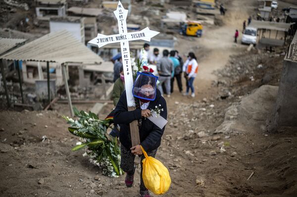 Родственник жертвы коронавируса несет крест по кладбищу на окраине Лимы, Перу - Sputnik Азербайджан
