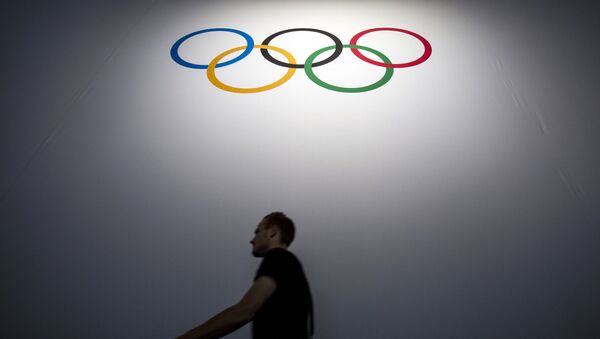 Человек на фоне олимпийской символики, фото из архива - Sputnik Азербайджан