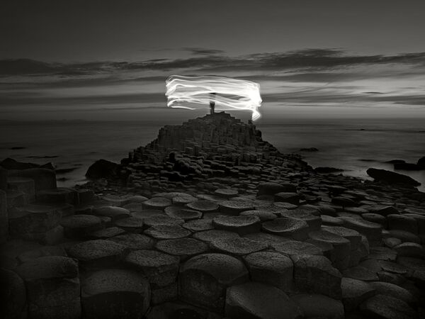 Снимок Giant's Causeway and figure, Northern Ireland фотографа  Ugo Ricciardi , занявший третье место в категории  Movement/Fine Art конкурса IPA OneShot Movement 2020 - Sputnik Азербайджан
