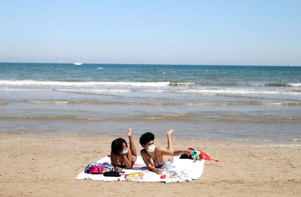 Девушки в защитных медицинских масках на пляже Malvarrosa в Валенсии, Испания - Sputnik Azərbaycan