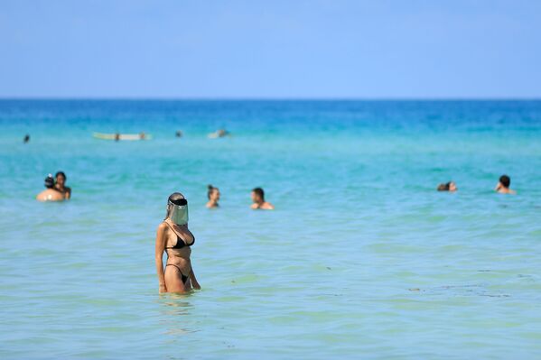 Женщина с защитным экраном на лице на пляже в Майами-Бич, Флорида - Sputnik Azərbaycan