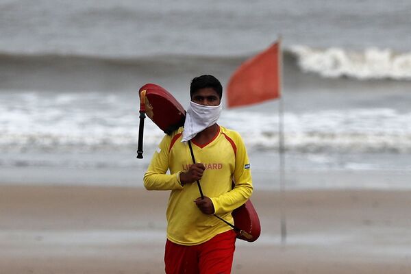Спасатель в самодельной маске на пляже Джуу в Мумбаи, Индия - Sputnik Азербайджан