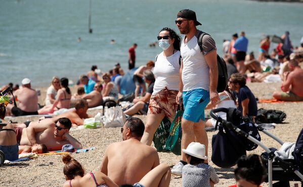 Пара в защитных масках на пляже в Саутенд-он-Си, Великобритания  - Sputnik Azərbaycan